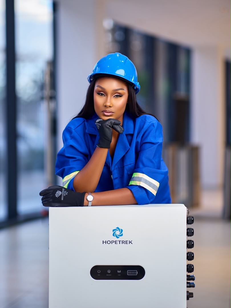 Technician in blue overalls with a Hopetrek home battery storage unit